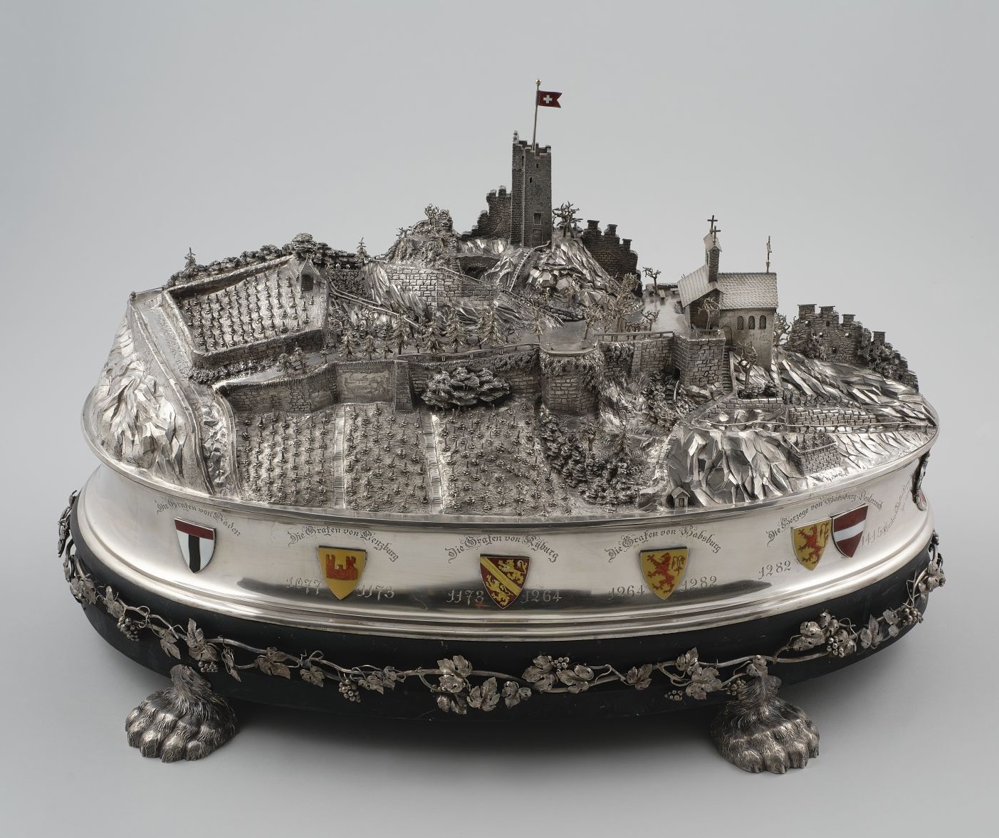Jean BaltenspergerTafelaufsatz in Form eines Burgmodells „Der Stein zu Baden“, 1881, Jean Baltensperger (1854-1908), Baden, Silber, transluzides Email, Holzsockel, H. 41 cm, L. 66 cm, B. 38 cm, HG13627, (Foto: Monika Runge)