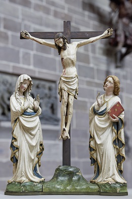 Eine  Kreuzigungsgruppe mit dem Kruzifix in der Mitte, rechts der Heilige Johannes und links Maria.
