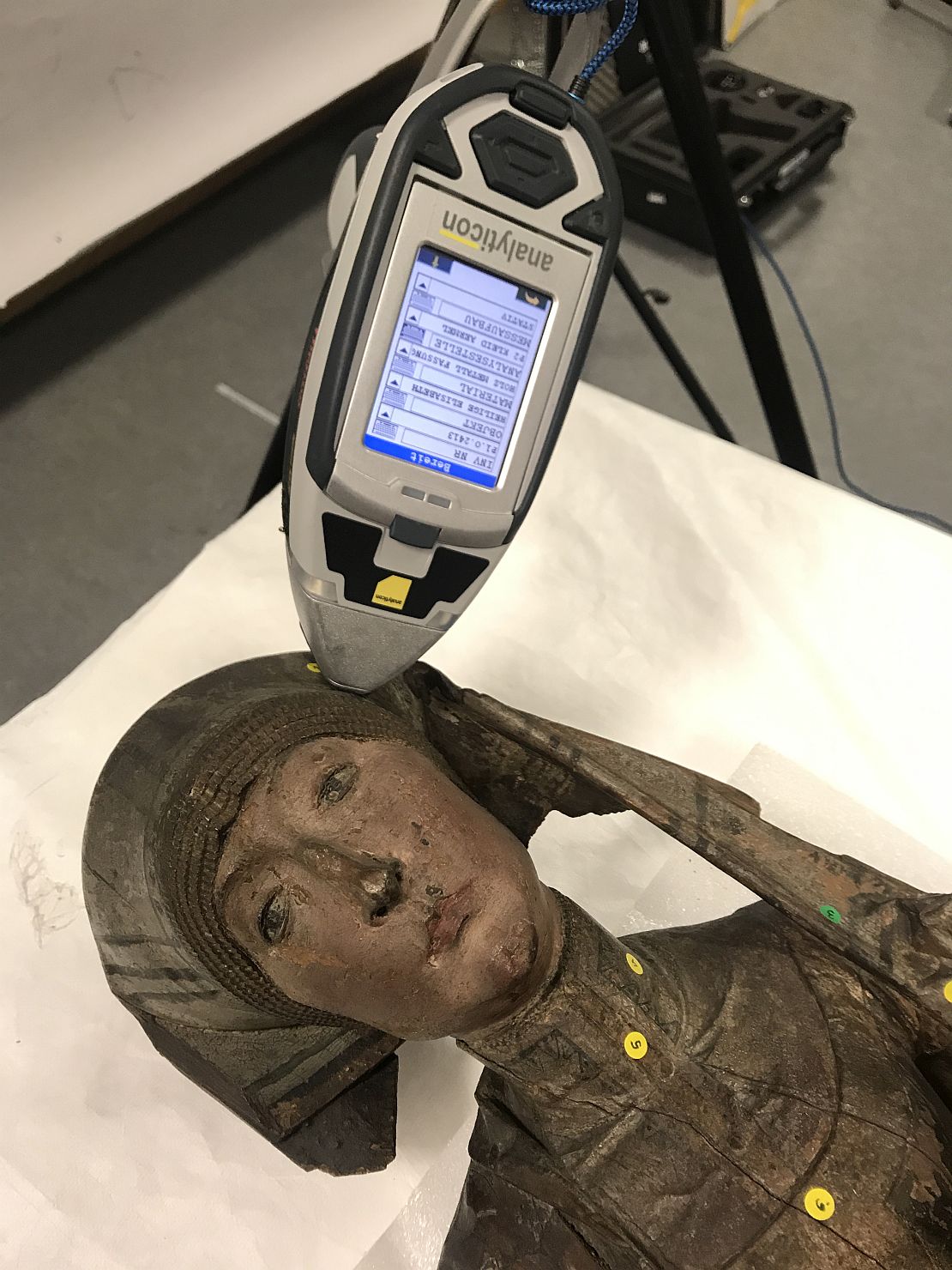 Die Skulptur der Heiligen Elisabeth liegt auf einem Tisch und wird mit einem mobilen Röntgengerät untersucht.